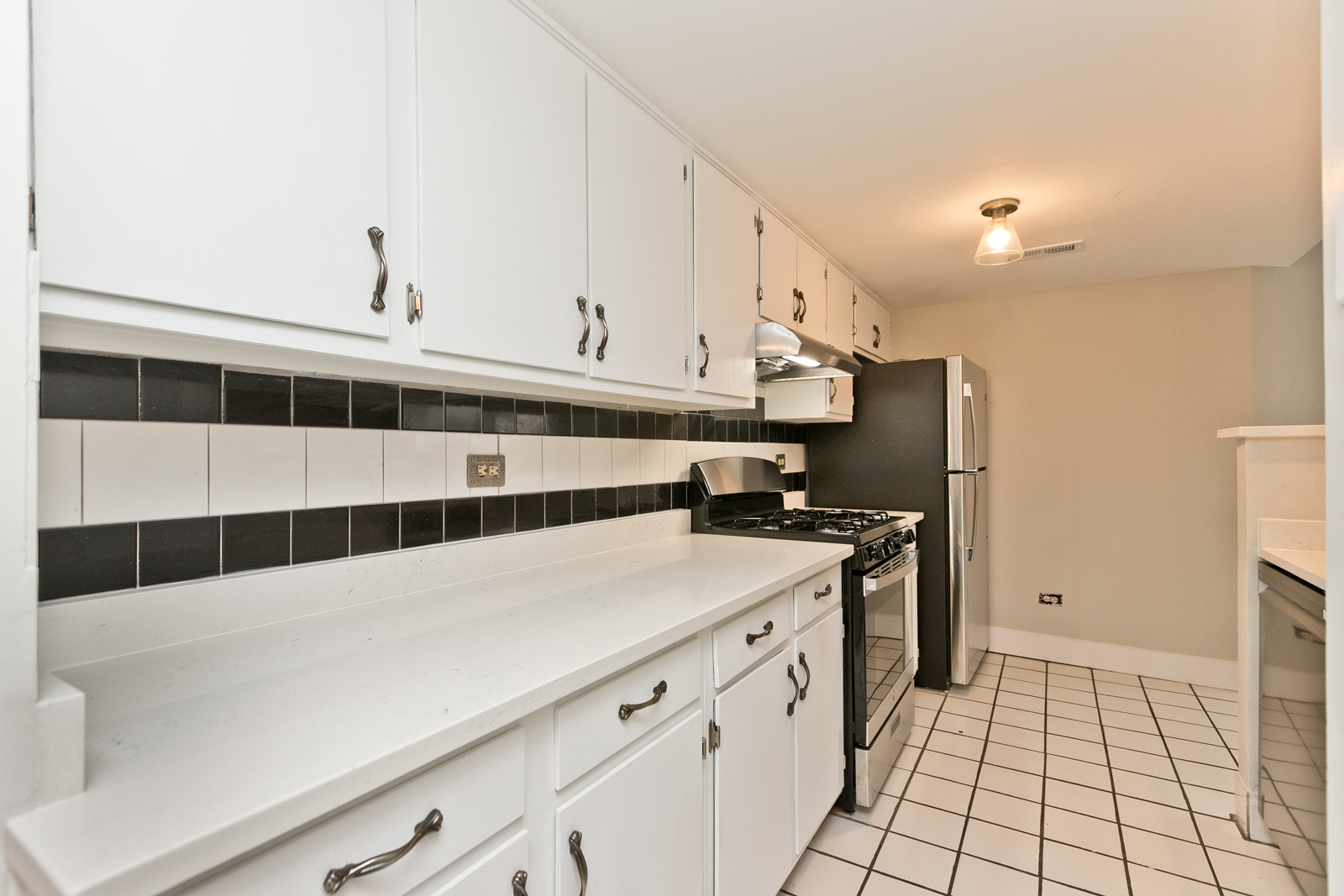 4061 North Sheridan Road, Unit G Chicago, IL 60613 - Photo 3 of 10 a kitchen with stainless steel appliances a sink and a refrigerator