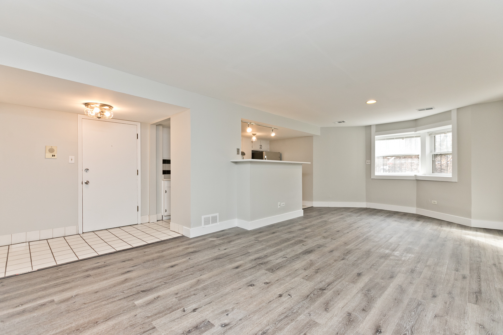 4061 North Sheridan Road, Unit G Chicago, IL 60613 - Photo 6 of 10 a view of an empty room with wooden floor and a window