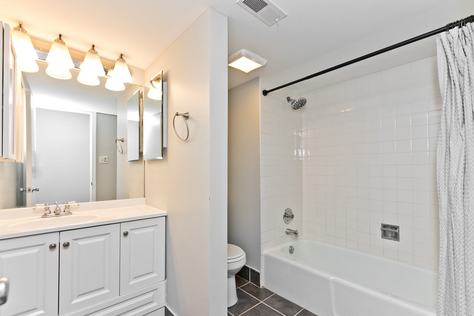 4061 North Sheridan Road, Unit G Chicago, IL 60613 - Photo 9 of 10 a bathroom with a bathtub shower sink vanity and a toilet