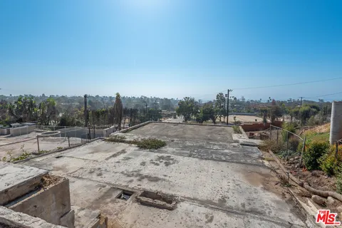 a view of a dry yard with wooden fence