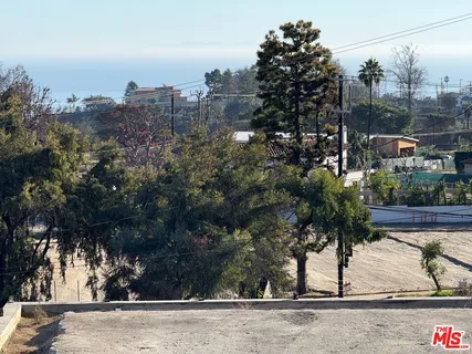 front view of a house with a yard and mountain view in back