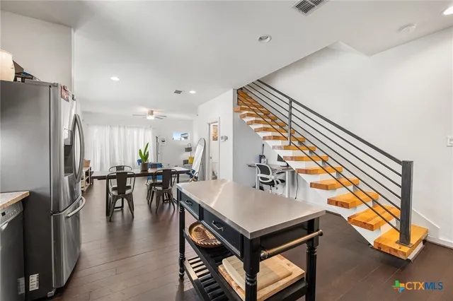 an open kitchen with dining table and stainless steel appliances