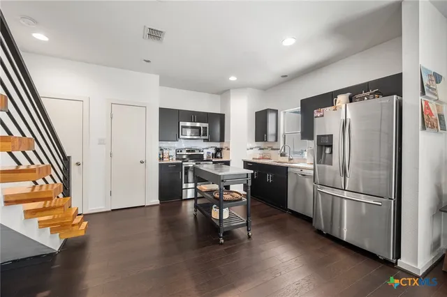 a kitchen with kitchen island white cabinets and stainless steel appliances