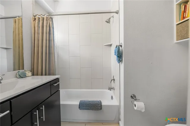 a bathroom with a granite countertop sink a shower and a mirror