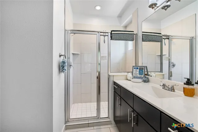 a bathroom with a double vanity sink mirror and shower