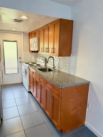 a kitchen with stainless steel appliances granite countertop a sink counter space and a window