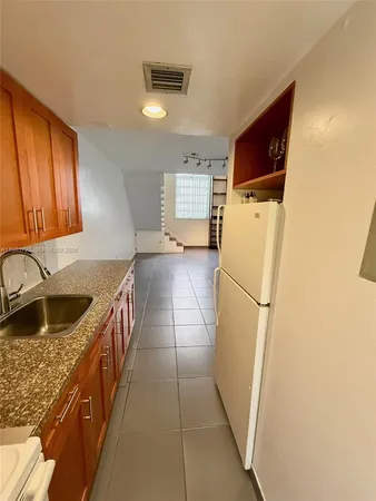 a kitchen with a refrigerator and a sink