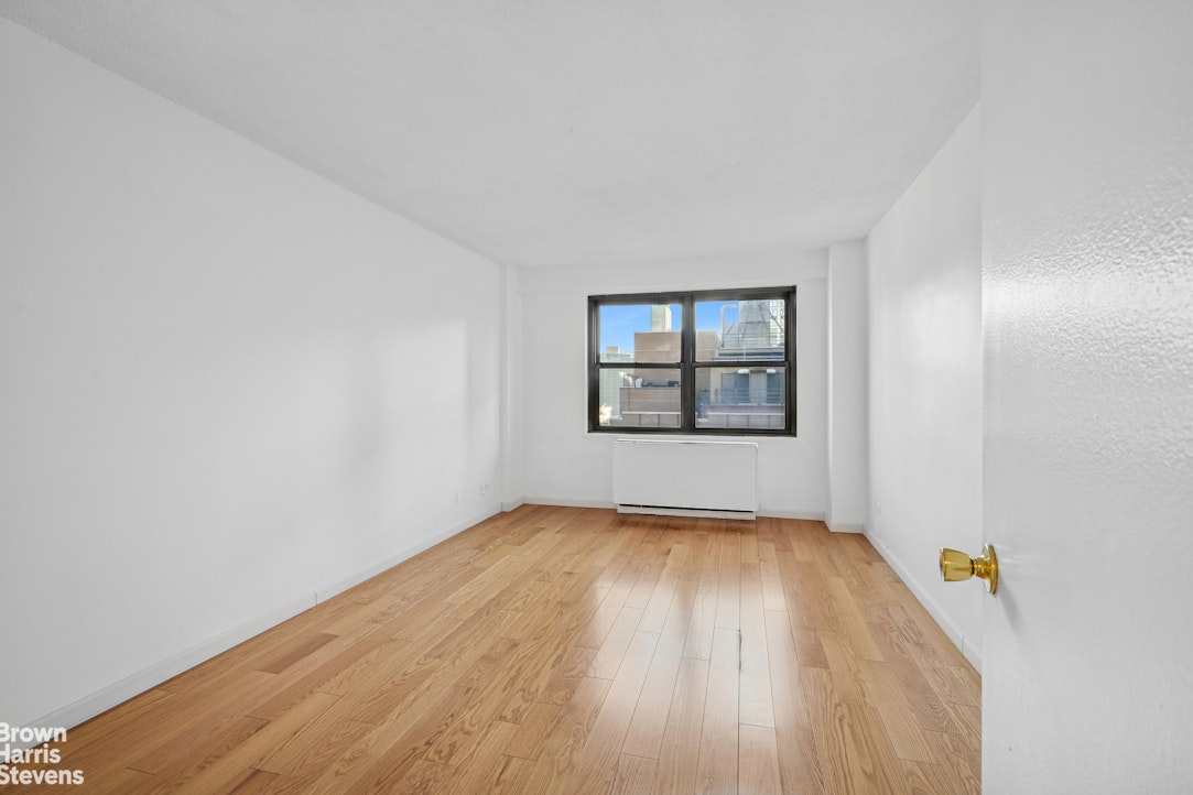 132 East 35th Street, Unit 16F Manhattan, NY 10016 - Photo 7 of 14 an empty room with wooden floor and windows