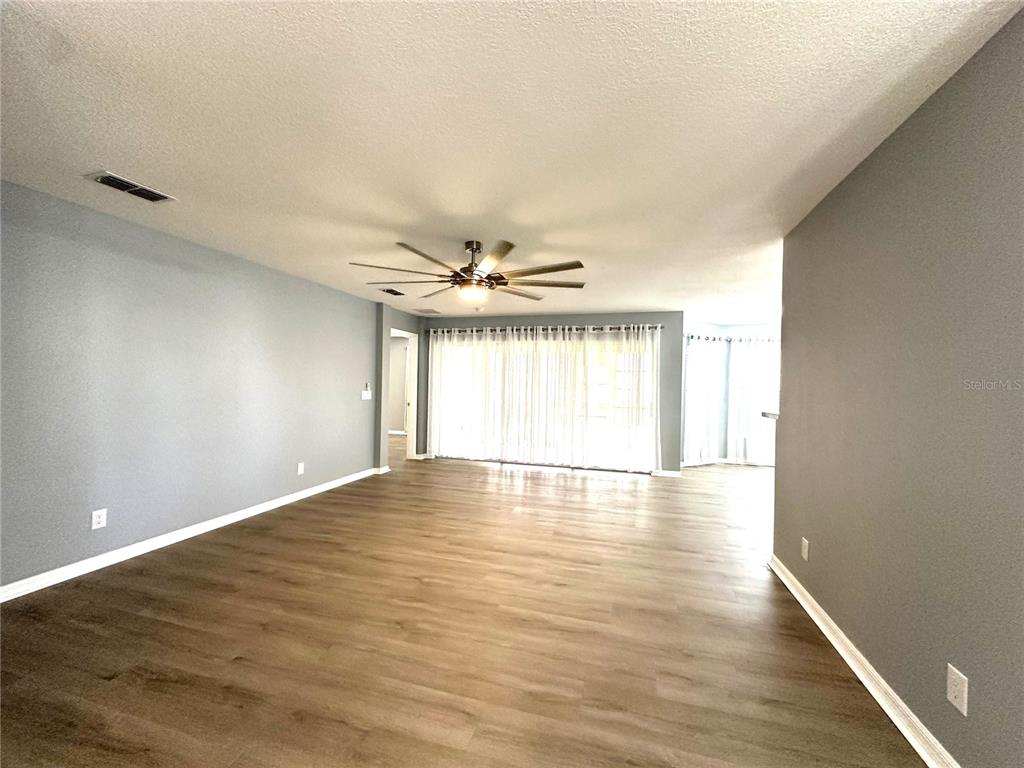 9706 Southwest 92nd Place Road Ocala, FL 34481 - Photo 6 of 82 an empty room with wooden floor and windows