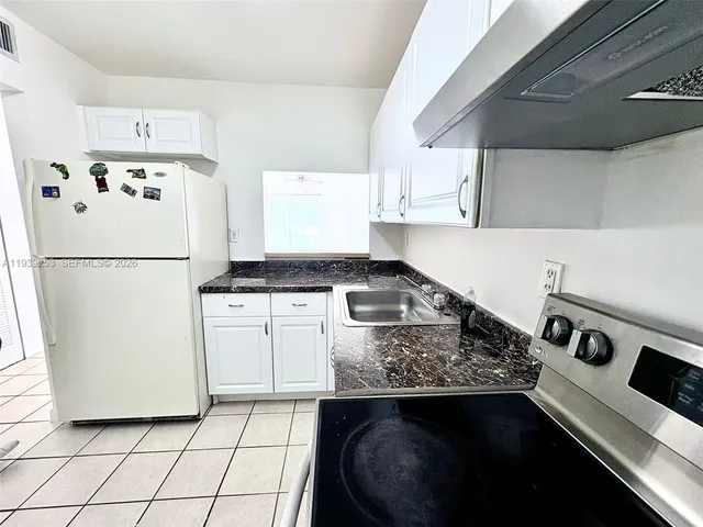 a kitchen with a sink a stove and cabinets