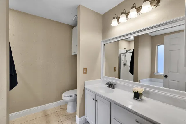 a bathroom with a sink a toilet and a mirror