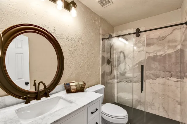 a bathroom with a sink a toilet and a mirror
