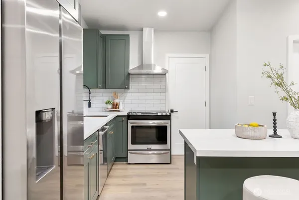 a kitchen with stainless steel appliances a stove and a refrigerator
