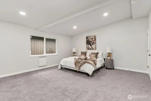 a spacious bedroom with a bed and a window