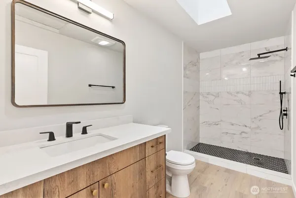 a bathroom with a sink a toilet and shower