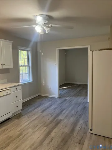 a view of an empty room with window and wooden floor