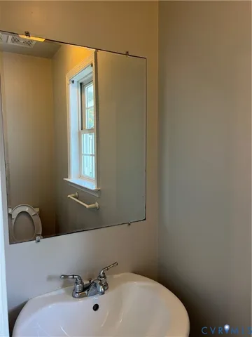 a bathroom with a sink a toilet and mirror