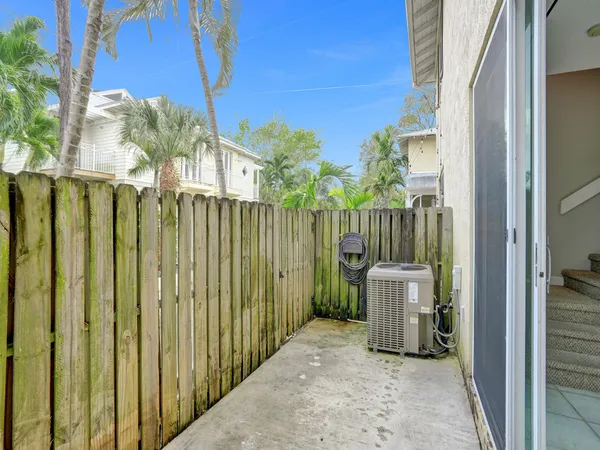a view of a house with a small yard and wooden fence