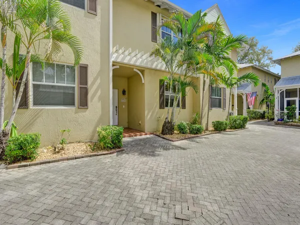 a front view of a house with a yard and potted plants
