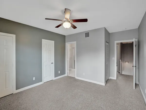 a view of an empty room with a ceiling fan