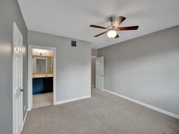 a view of an empty room with a ceiling fan