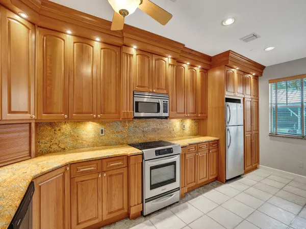 a kitchen with stainless steel appliances granite countertop a refrigerator and a sink