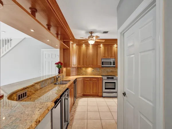 a kitchen with stainless steel appliances granite countertop a sink and dishwasher a stove top oven with wooden floor