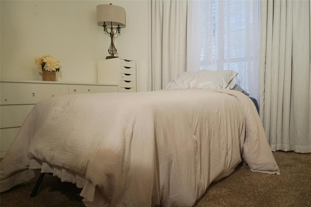 286 West Ridge Street Decatur, TX 76234 - Photo 20 of 35 a bedroom with a bed and a chandelier