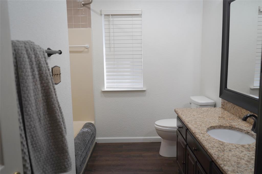 286 West Ridge Street Decatur, TX 76234 - Photo 22 of 35 a bathroom with a granite countertop sink toilet and a mirror