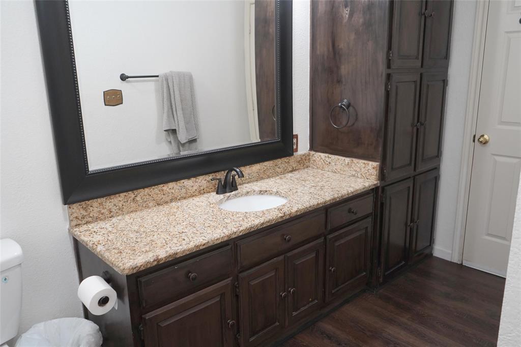 286 West Ridge Street Decatur, TX 76234 - Photo 23 of 35 a bathroom with a granite countertop sink and a mirror
