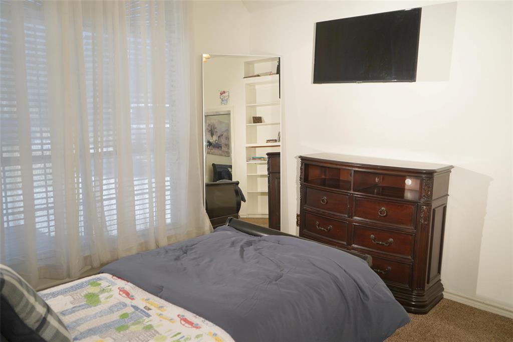 286 West Ridge Street Decatur, TX 76234 - Photo 28 of 35 a bedroom with a bed and a flat tv screen on dresser