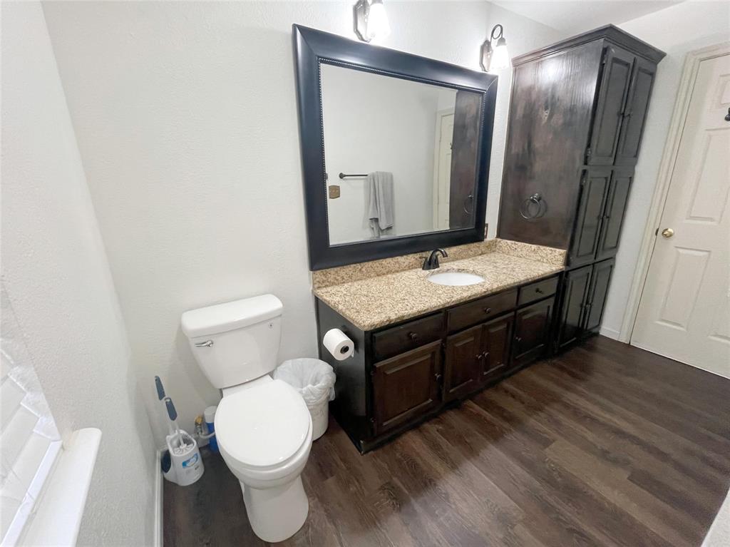 286 West Ridge Street Decatur, TX 76234 - Photo 31 of 35 a bathroom with a granite countertop toilet sink and mirror