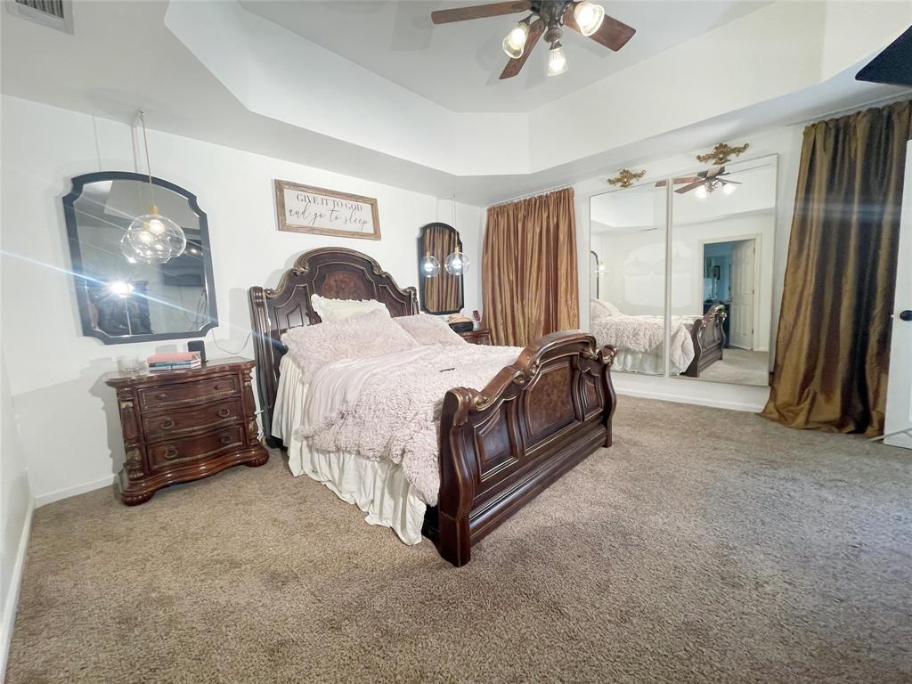 286 West Ridge Street Decatur, TX 76234 - Photo 32 of 35 a bed room with a bed and a chandelier