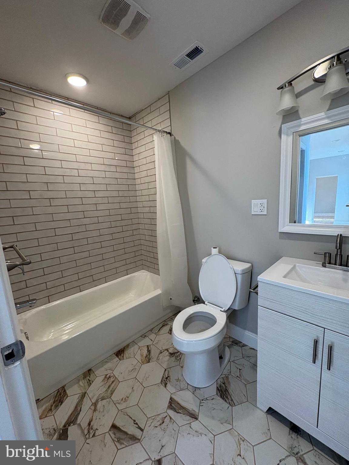 2900 North 5th Street, Unit 2 Philadelphia, PA 19133 - Photo 6 of 8 a bathroom with a granite countertop toilet sink and mirror