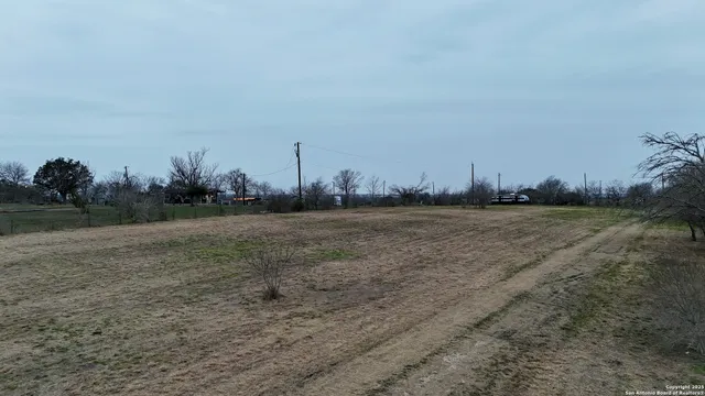 a view of a field with trees in background