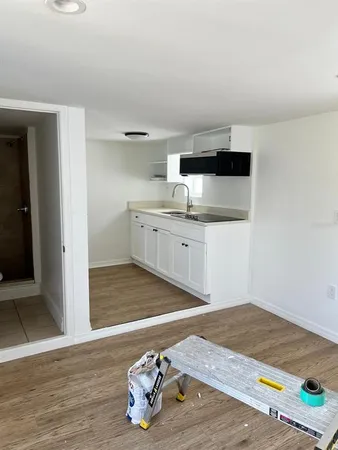 a kitchen with a sink cabinets and wooden floor