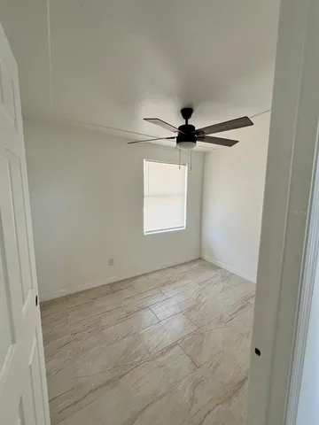 a view of empty room with ceiling fan
