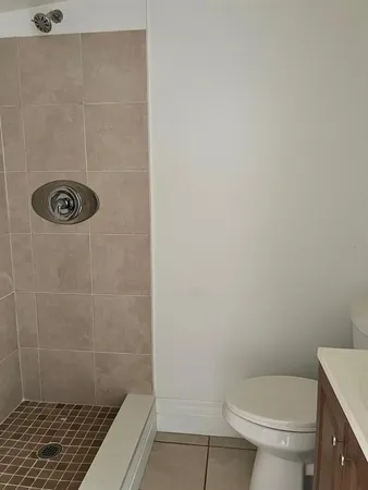 a white toilet sitting next to a shower