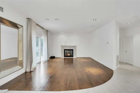 a view of a livingroom with wooden floor and a fireplace