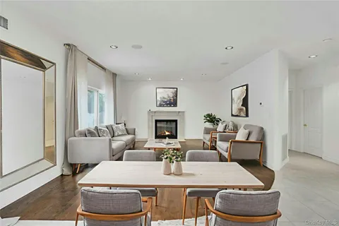 a view of a dining room with furniture a fireplace and wooden floor