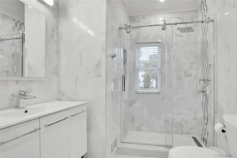 a bathroom with a shower sink and mirror