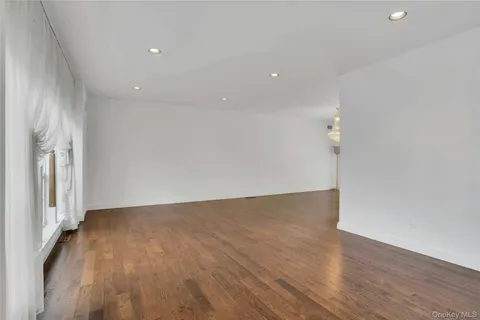 an empty room with wooden floor and a window