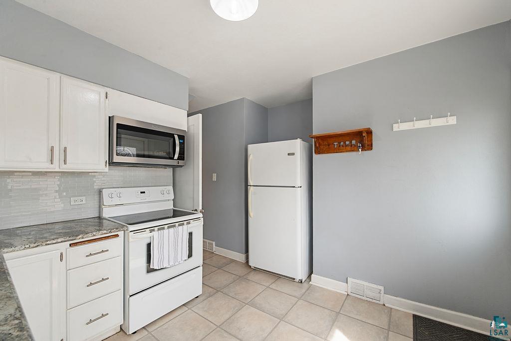 122 3rd Street Cloquet, MN 55720 - Photo 6 of 42 Kitchen featuring white cabinetry, light gray subway tile backsplash, and light-colored countertops