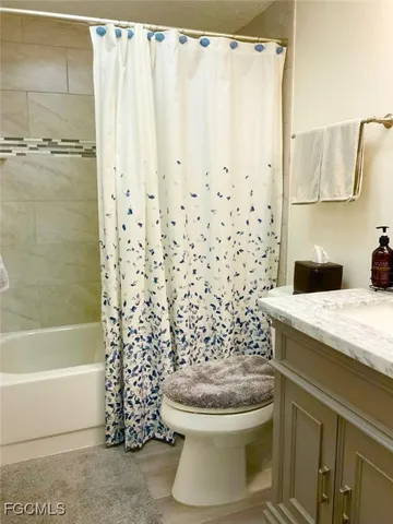 a bathroom with a granite countertop toilet and a shower