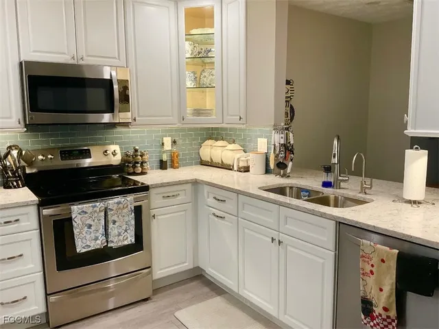 a kitchen with stainless steel appliances granite countertop a sink a stove and a microwave