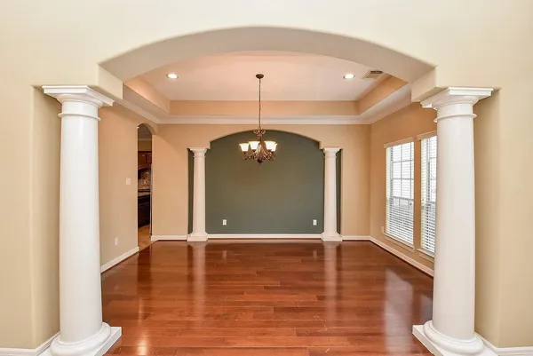a view of a hallway with windows and chandelier