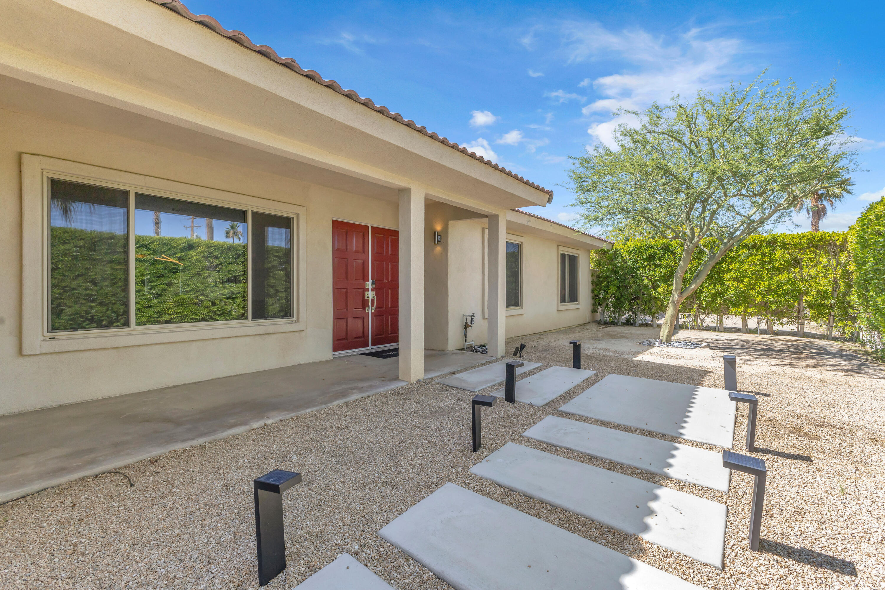 2355 West Nicola Road Palm Springs, CA 92262 - Photo 11 of 54 a building exterior with furniture and garden