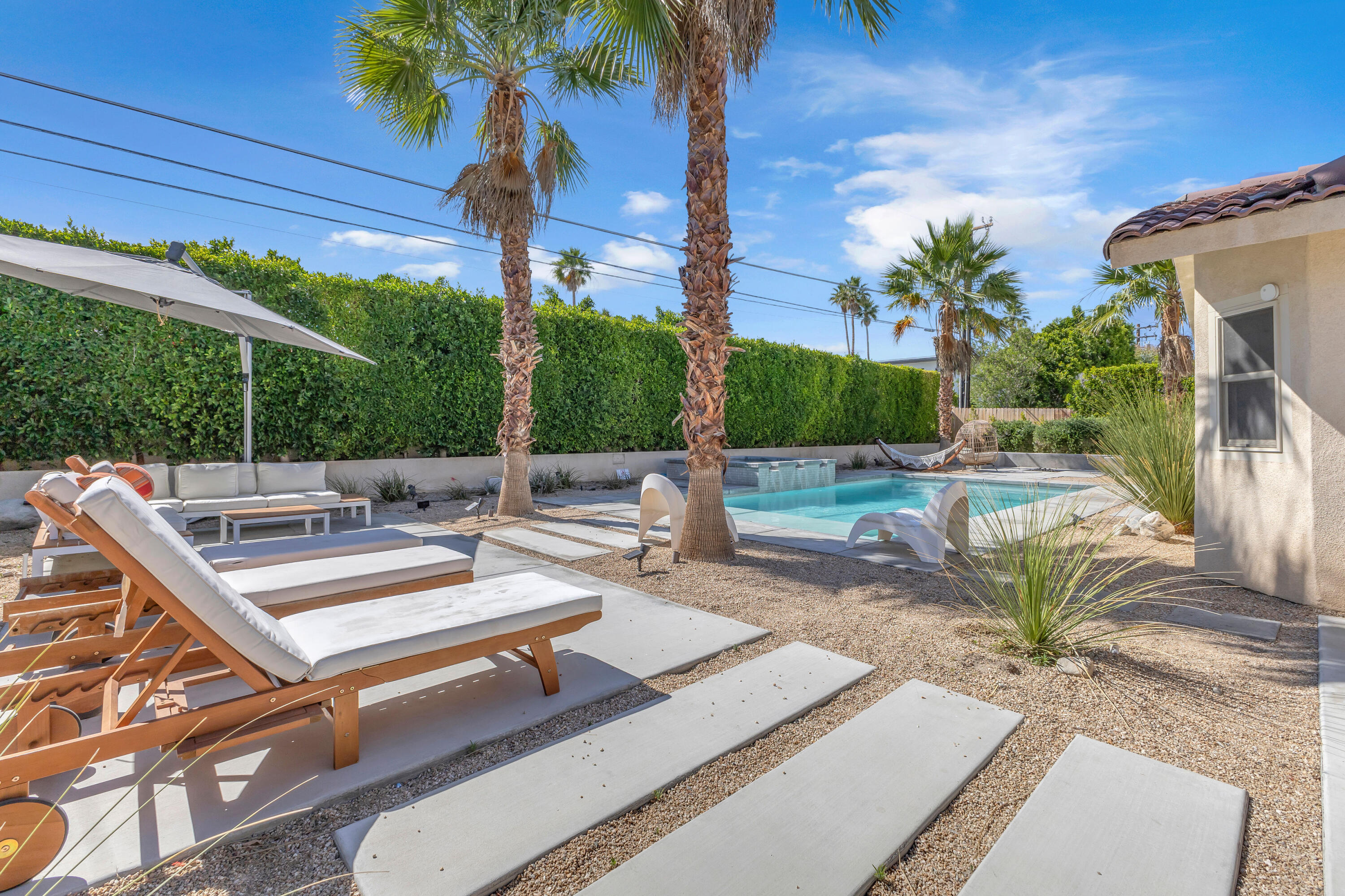 2355 West Nicola Road Palm Springs, CA 92262 - Photo 46 of 54 a view of a patio with couches table and chairs potted plants and palm tree