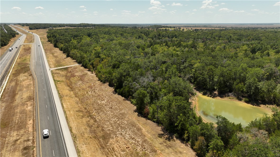 5131 North State Highway Hearne, TX 77859 - Photo 11 of 16 Aerial view of a forest, a nearby body of water, and a major roadway