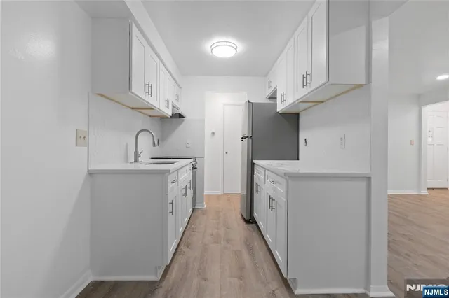 a kitchen with white cabinets and sink